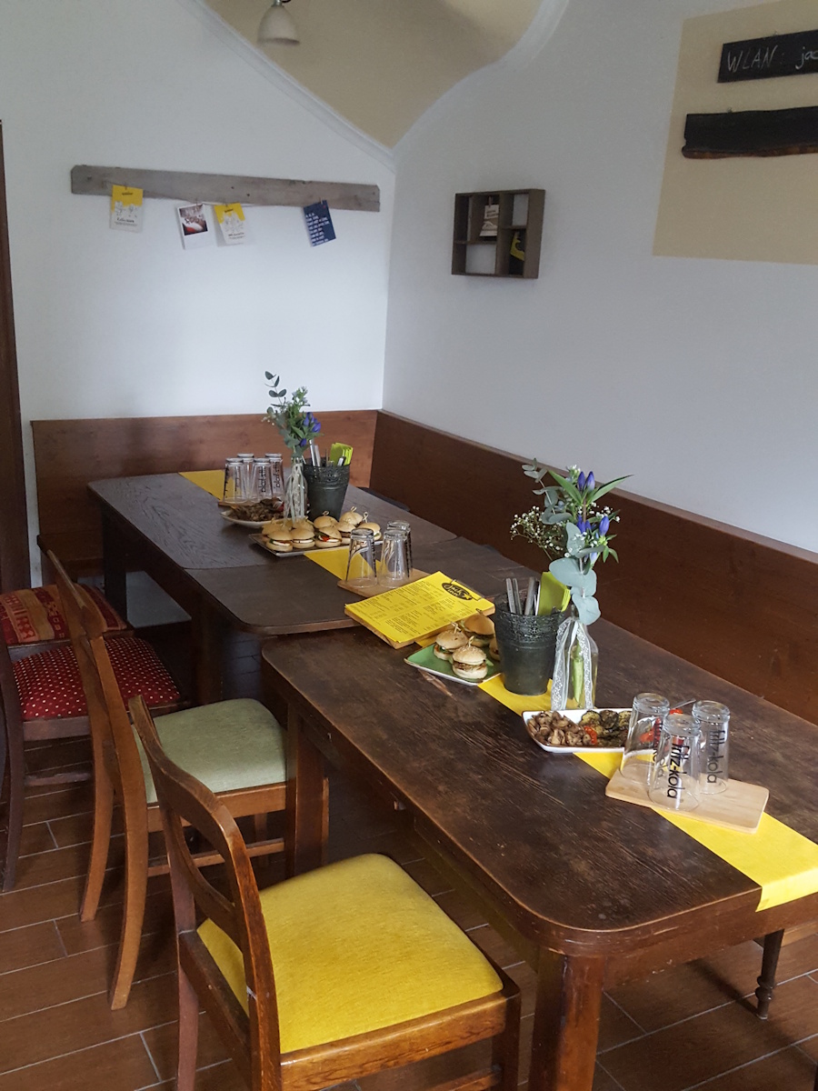 gaststube: dekoriert für einen feier, zwei alte holtische aneinander mit stühlen und vor einer eckbank.
                ein gelber tischläufer auf dem besteck, gläser, blumen und vorspeisen stehen. eine getränkekarte für die wahl ihrer getränke.
                vorspeise: miniburger und mariniertes, gebackenes gemüße....champignons, zucchini und spitzpaprika